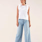 Blusa bianca con volant e fiocco sul retro