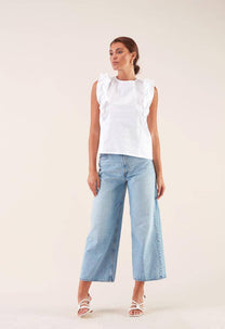 Blusa bianca con volant e fiocco sul retro