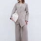 Completo elegante con blazer asimmetrico e pantaloni palazzo con bottoni gioiello