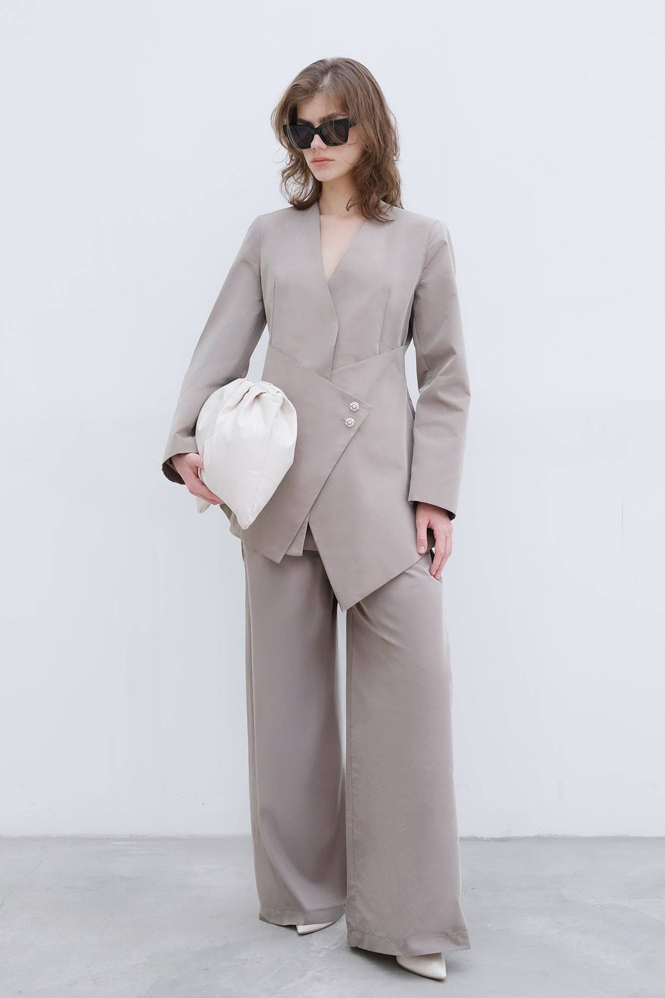 Completo elegante con blazer asimmetrico e pantaloni palazzo con bottoni gioiello