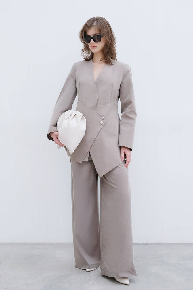 Completo elegante con blazer asimmetrico e pantaloni palazzo con bottoni gioiello