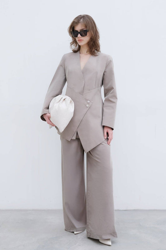 Completo elegante con blazer asimmetrico e pantaloni palazzo con bottoni gioiello
