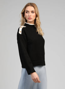 Maglione nero con collo alto e bottoni gioiello sulle spalle