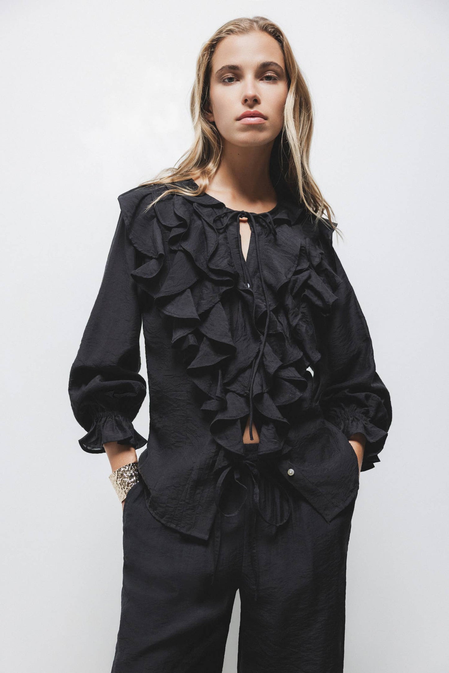 Blusa nera con volant e laccio al collo