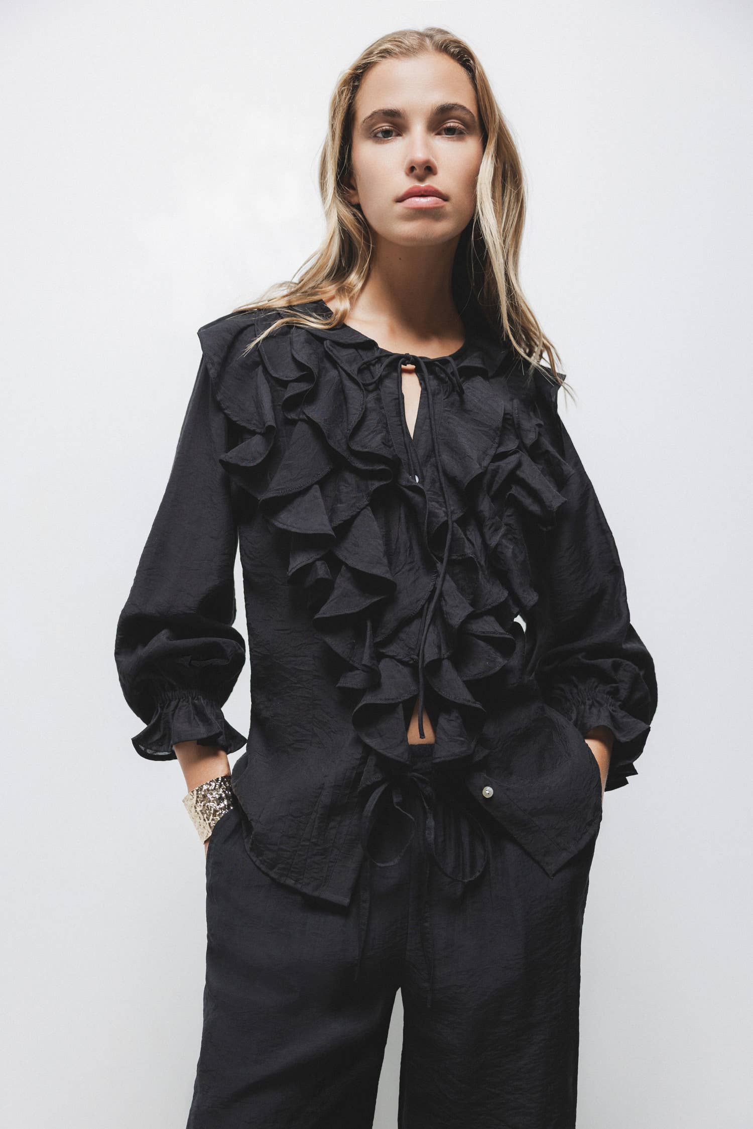 Blusa nera con volant e laccio al collo