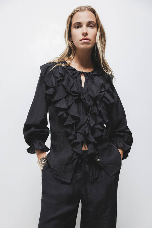 Blusa nera con volant e laccio al collo