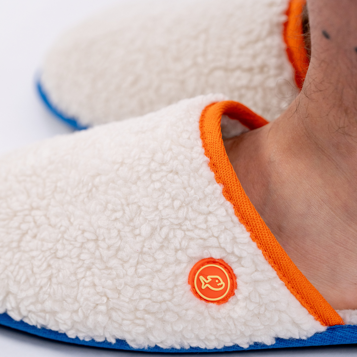 Pantofole in sherpa con dettagli arancioni e blu