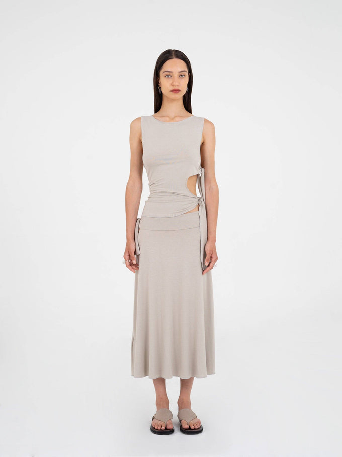 Top asimmetrico luminoso con cut-out e fiocco