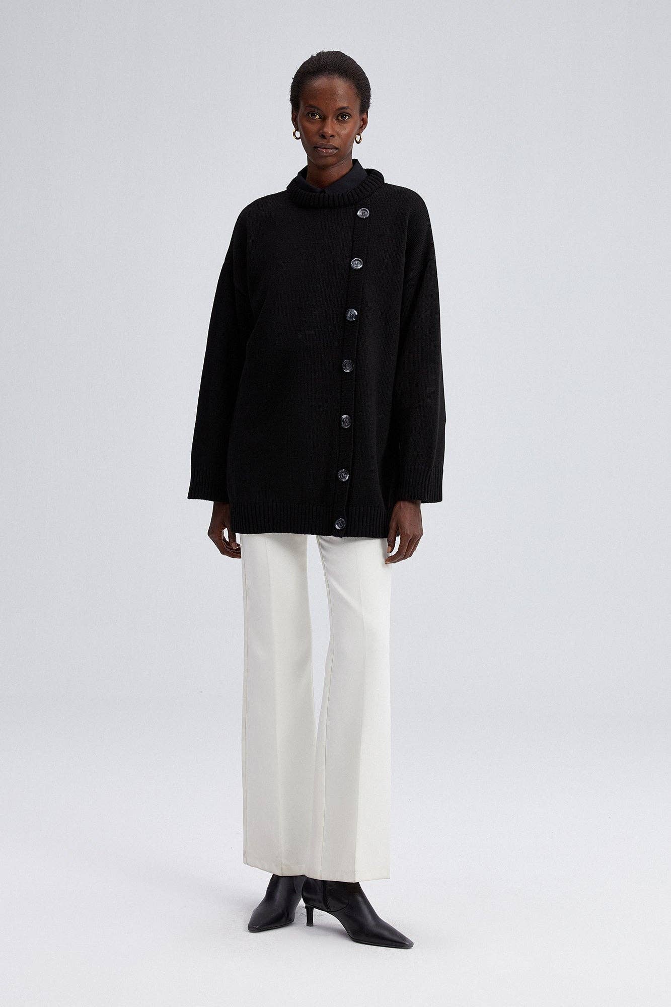 Maglione nero oversize con bottoni asimmetrici