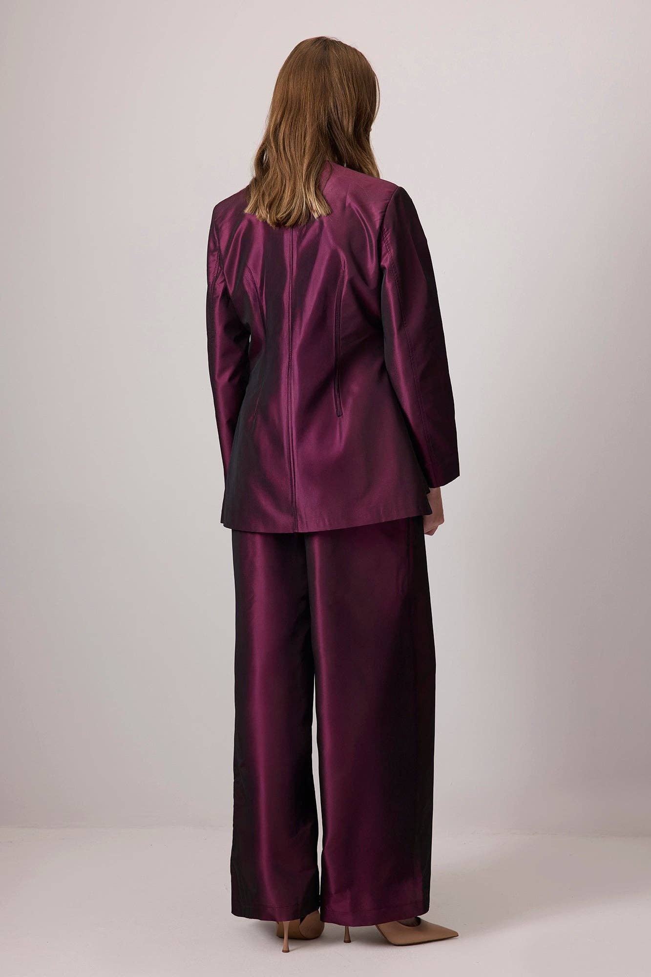 Completo in raso bordeaux con giacca asimmetrica e pantaloni a gamba larga