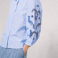 Blusa azzurra con maniche ricamate