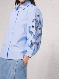 Blusa azzurra con maniche ricamate