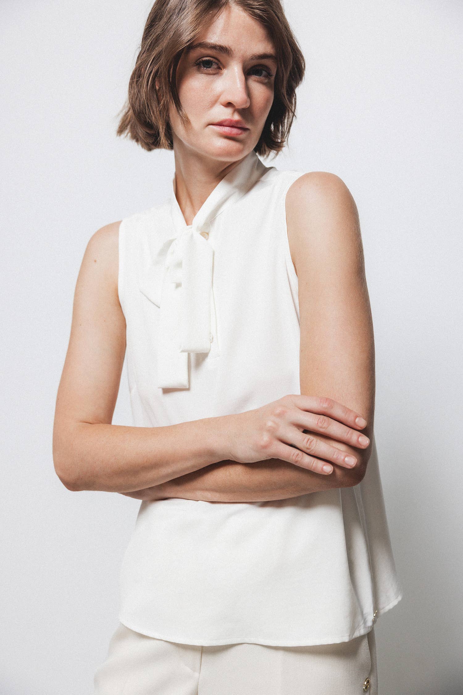 Top minimal con collo alto e fiocco