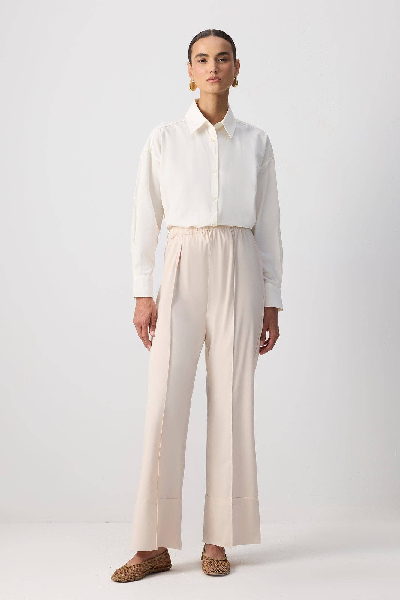 Pantaloni essenziali crema con orlo grezzo e cucitura frontale