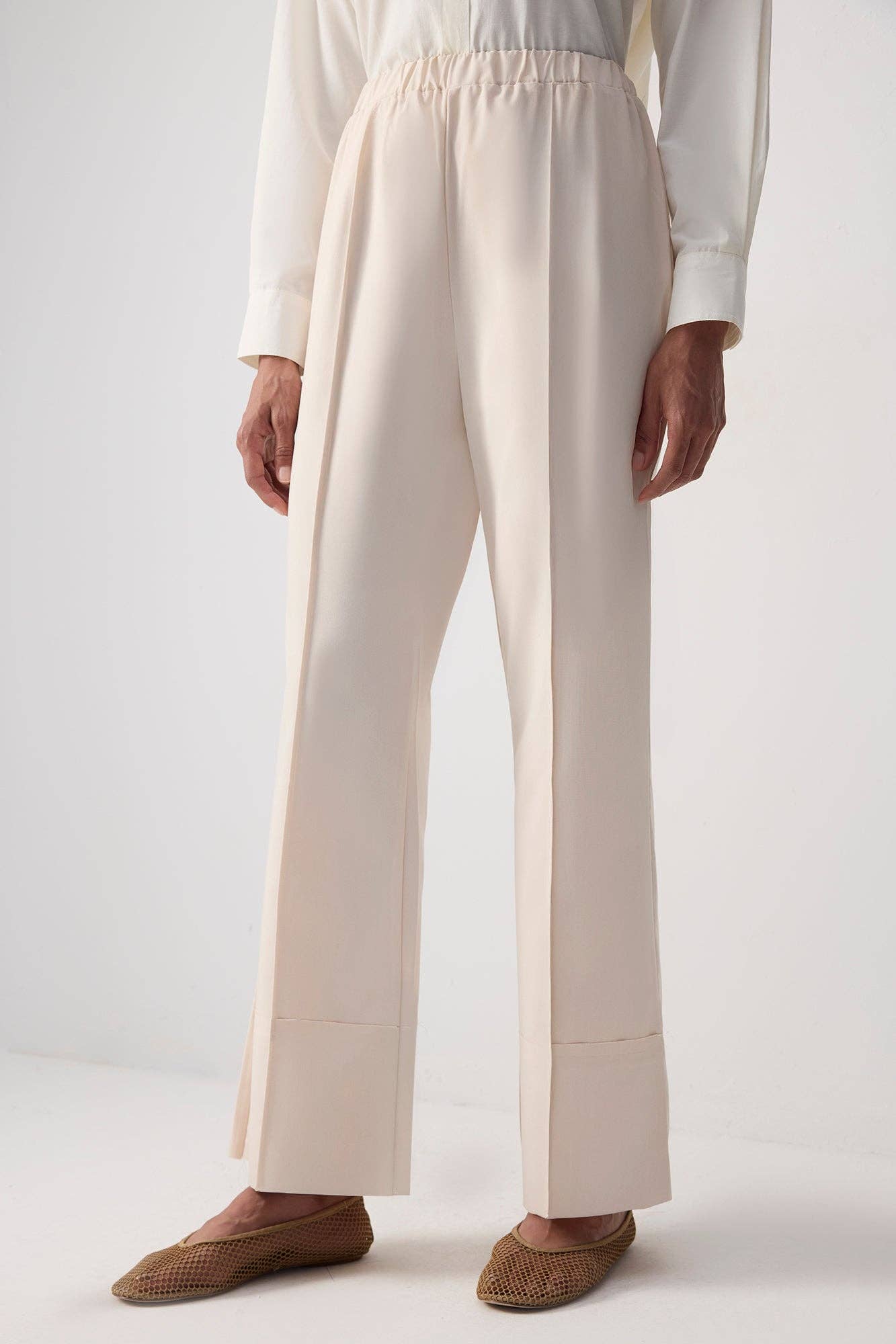 Pantaloni essenziali crema con orlo grezzo e cucitura frontale