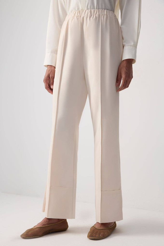 Pantaloni essenziali crema con orlo grezzo e cucitura frontale
