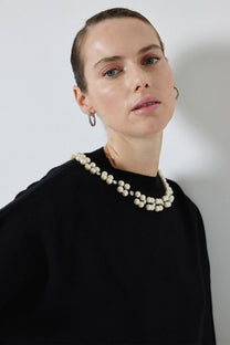 Maglione nero in maglia con perle applicate