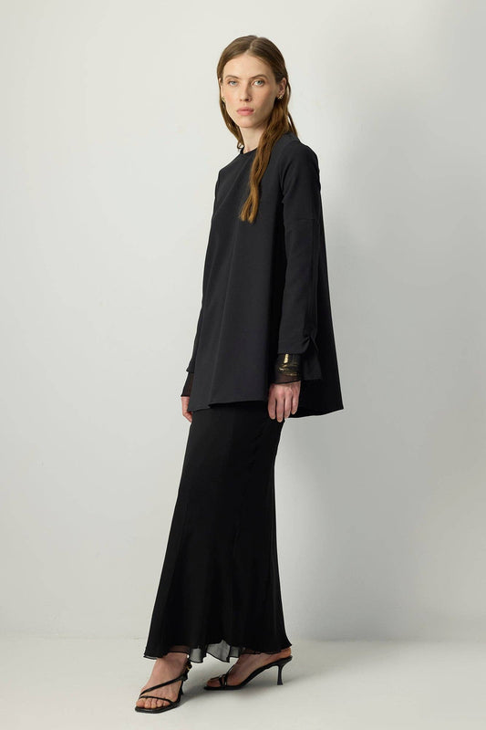 Tunica in crêpe nera con polsini in chiffon trasparente