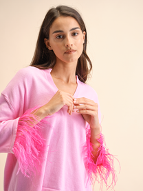 Maglia rosa con polsini in piume