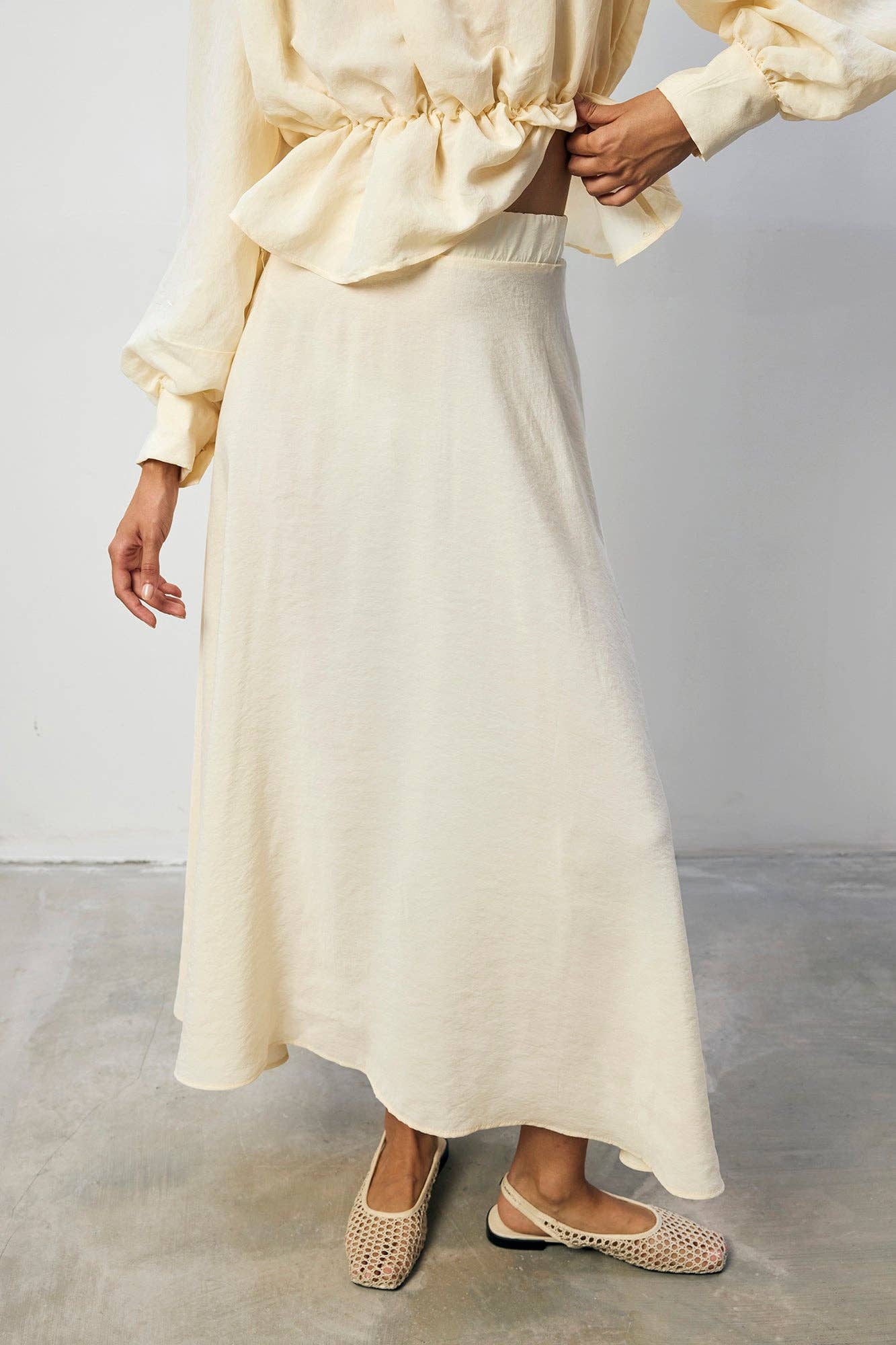 Set coordinato crema con blusa peplo e gonna maxi