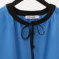 Blusa in misto lino blu con bordo a contrasto e fiocco al collo