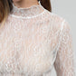 Top in pizzo bianco a maniche lunghe con collo alto