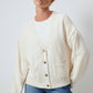 Cardigan in maglia crema con tasche e bottoni