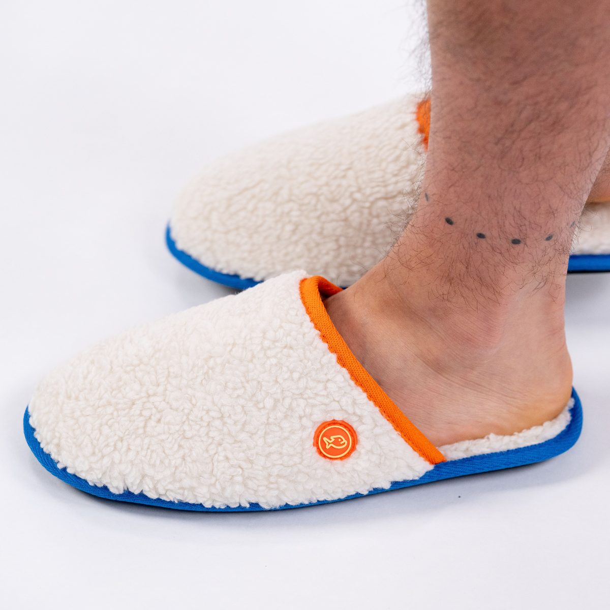 Pantofole in sherpa con dettagli arancioni e blu