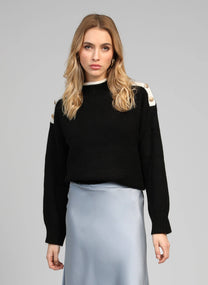 Maglione nero con collo alto e bottoni gioiello sulle spalle