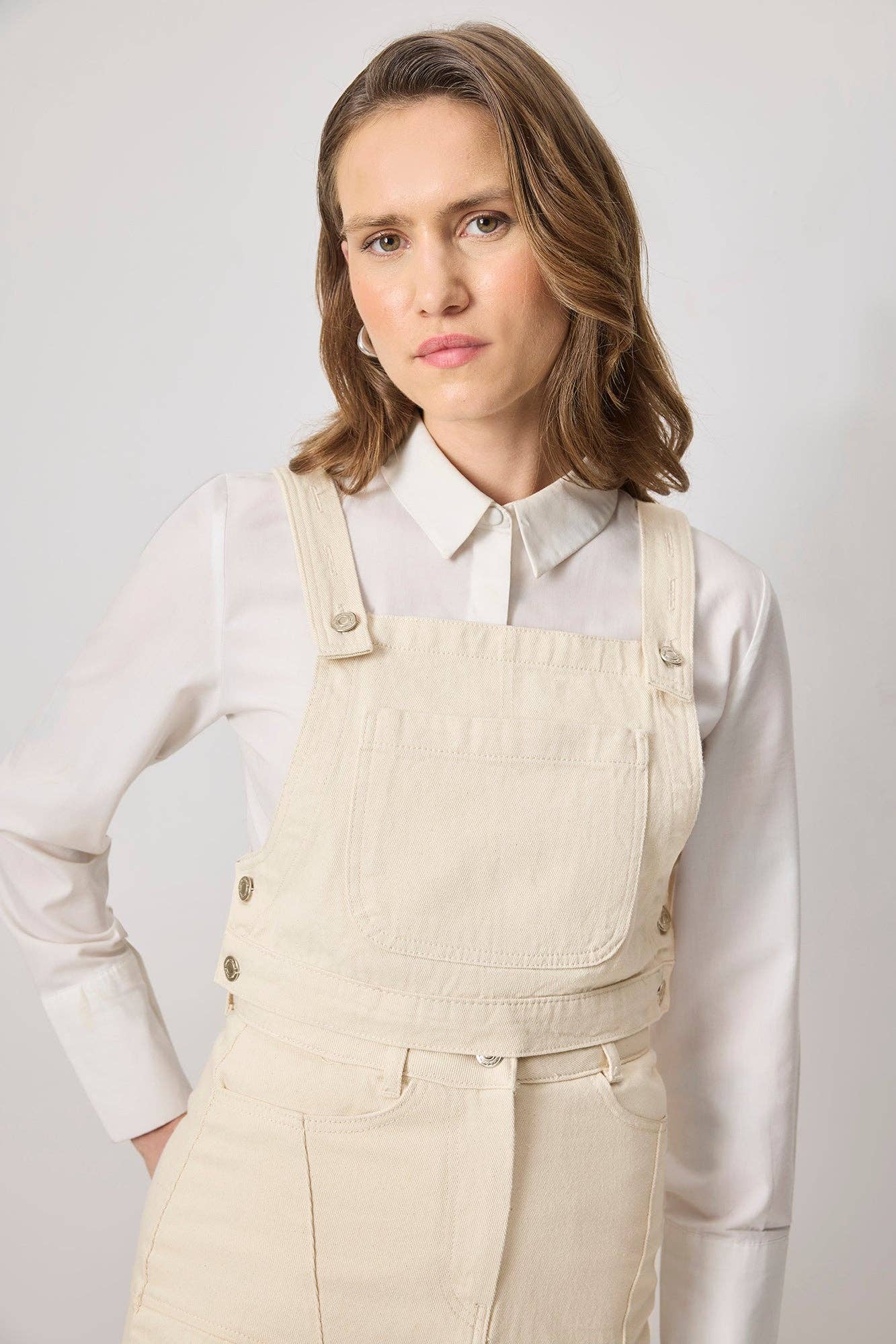 Top crop in denim ecrù con bretelle