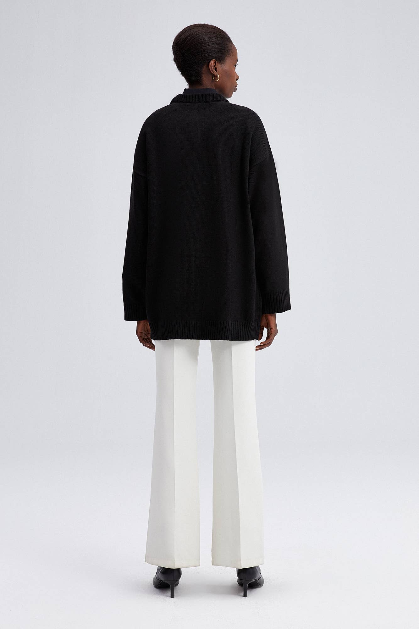 Maglione nero oversize con bottoni asimmetrici