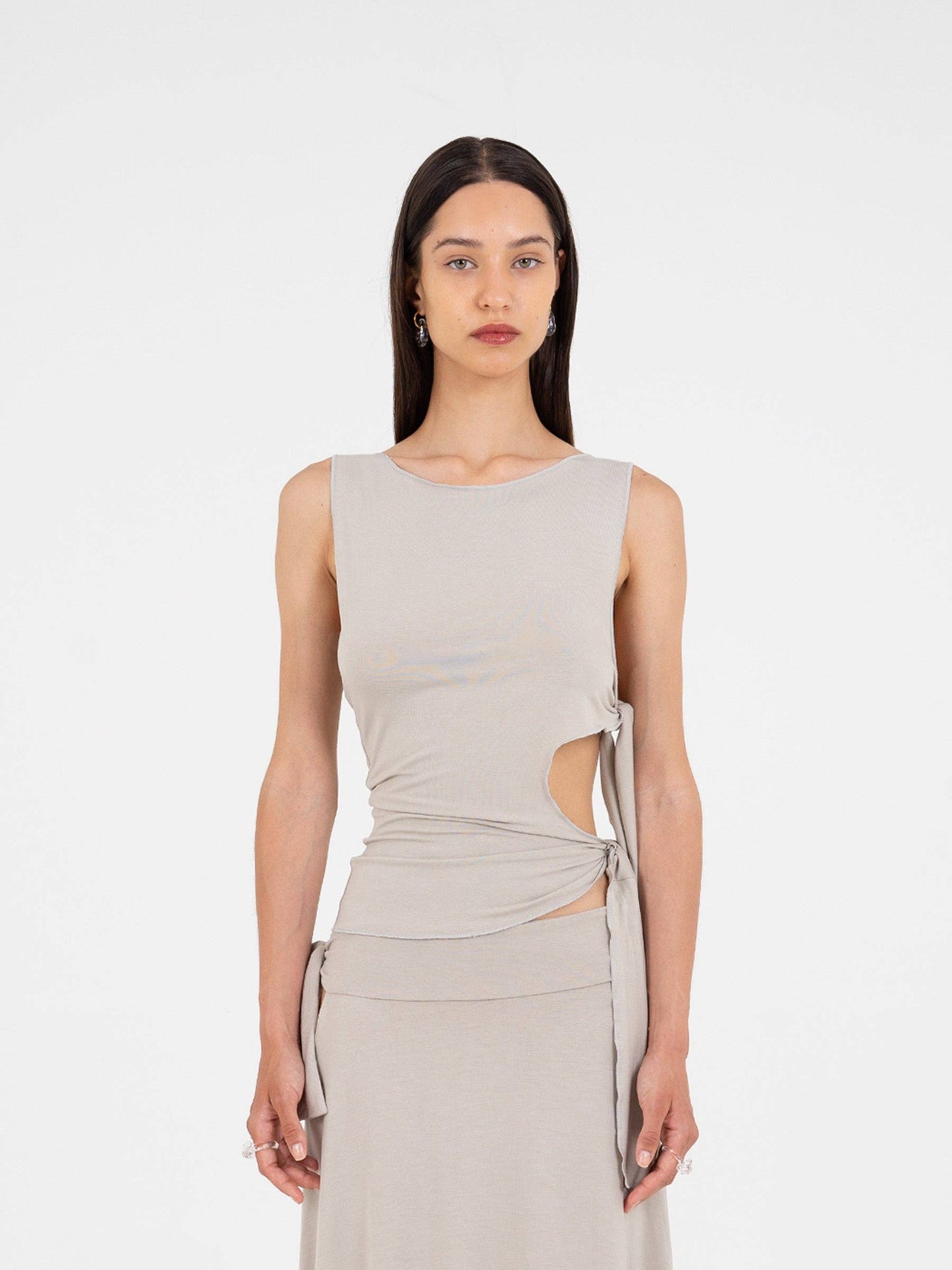 Top asimmetrico luminoso con cut-out e fiocco