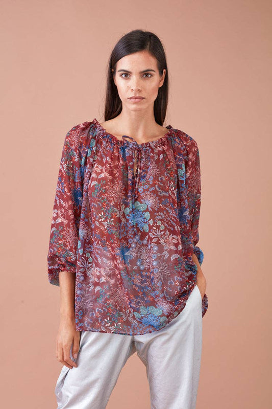 Blusa stampata con rouches e scollo con laccetto