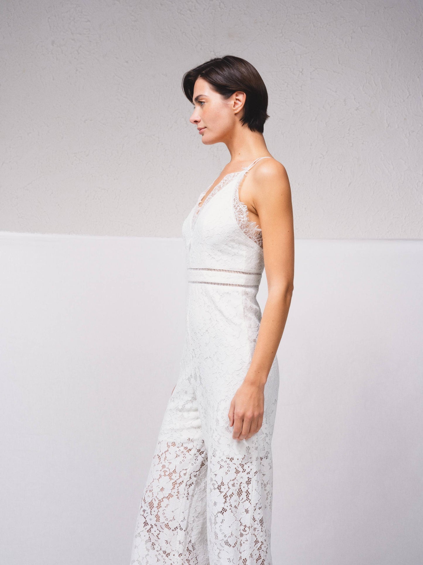 Tuta intera in pizzo con scollo a V e spalline incrociate