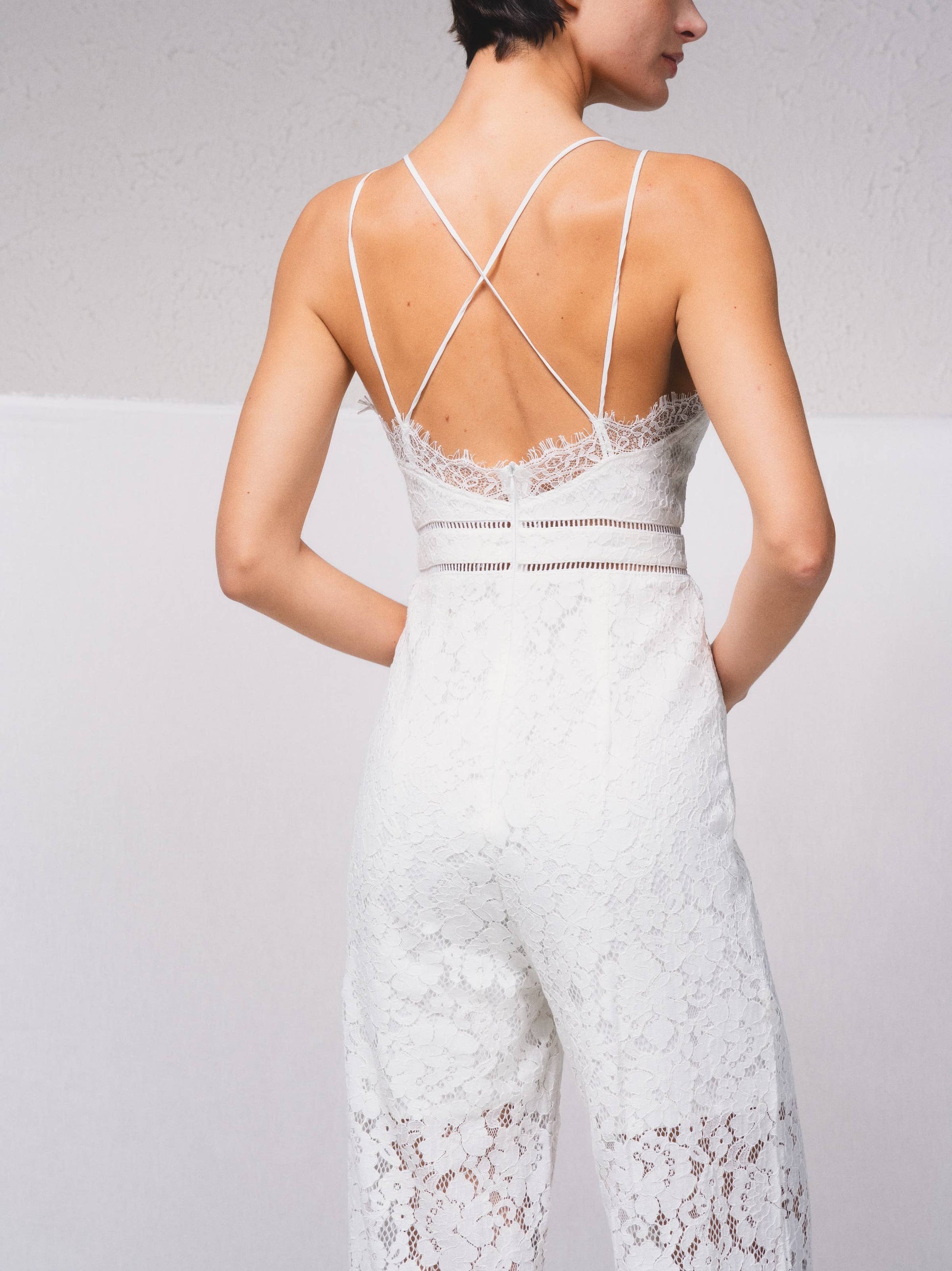 Tuta intera in pizzo con scollo a V e spalline incrociate
