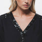 Blusa nera con paillettes e scollo a V