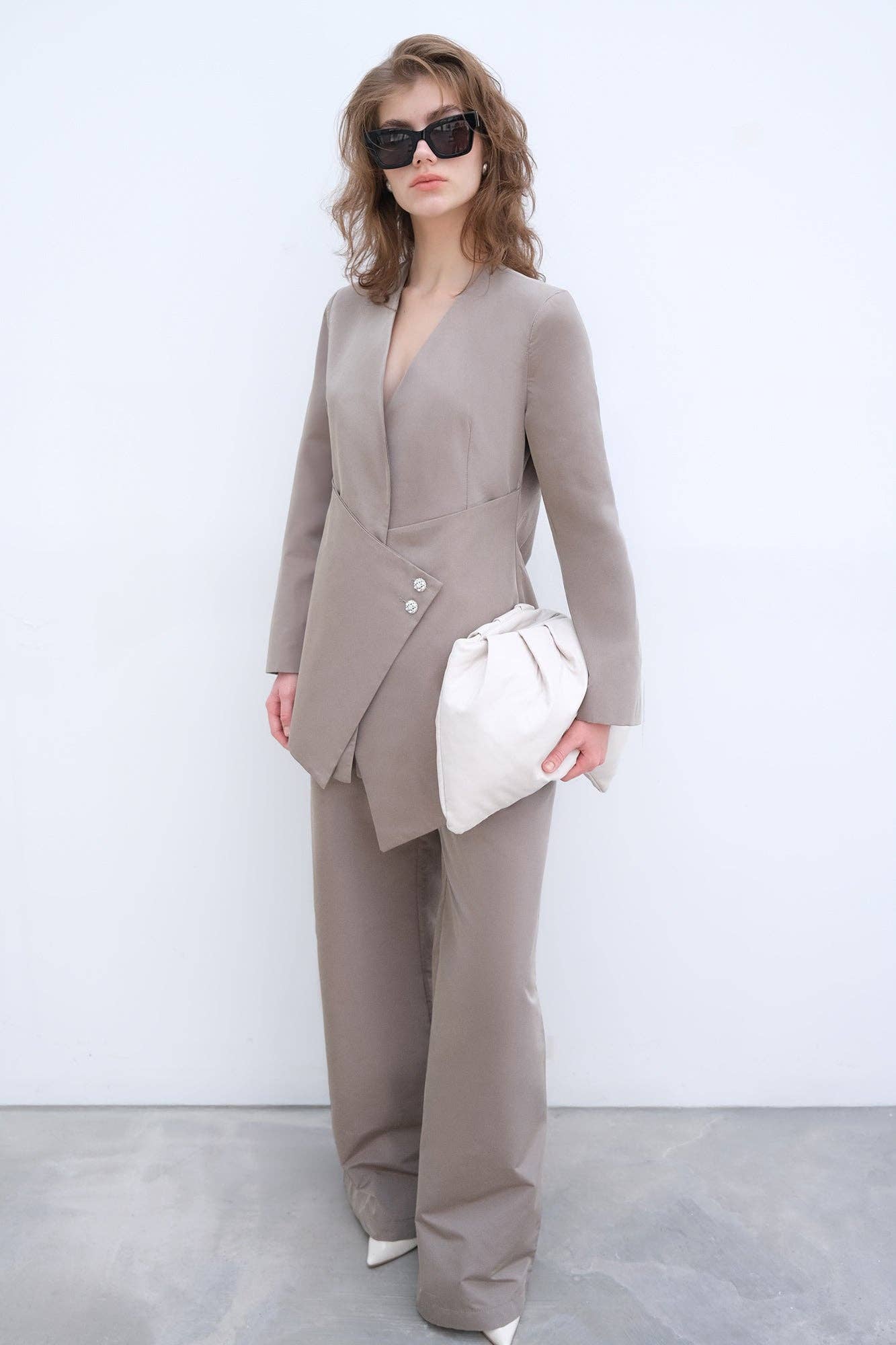 Completo elegante con blazer asimmetrico e pantaloni palazzo con bottoni gioiello