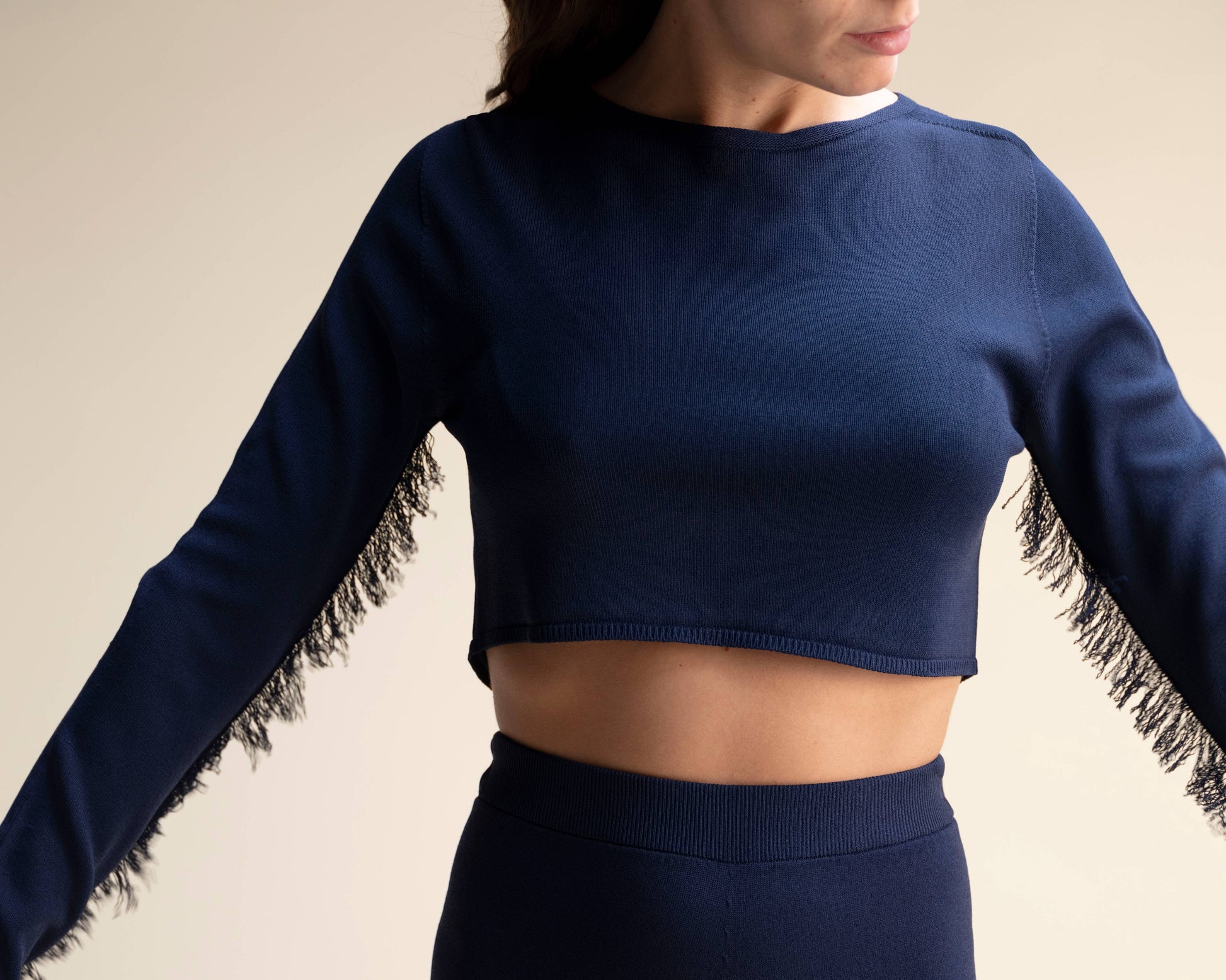 Top corto in maglia con frange sulle maniche