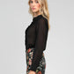 Blusa nera trasparente con volant