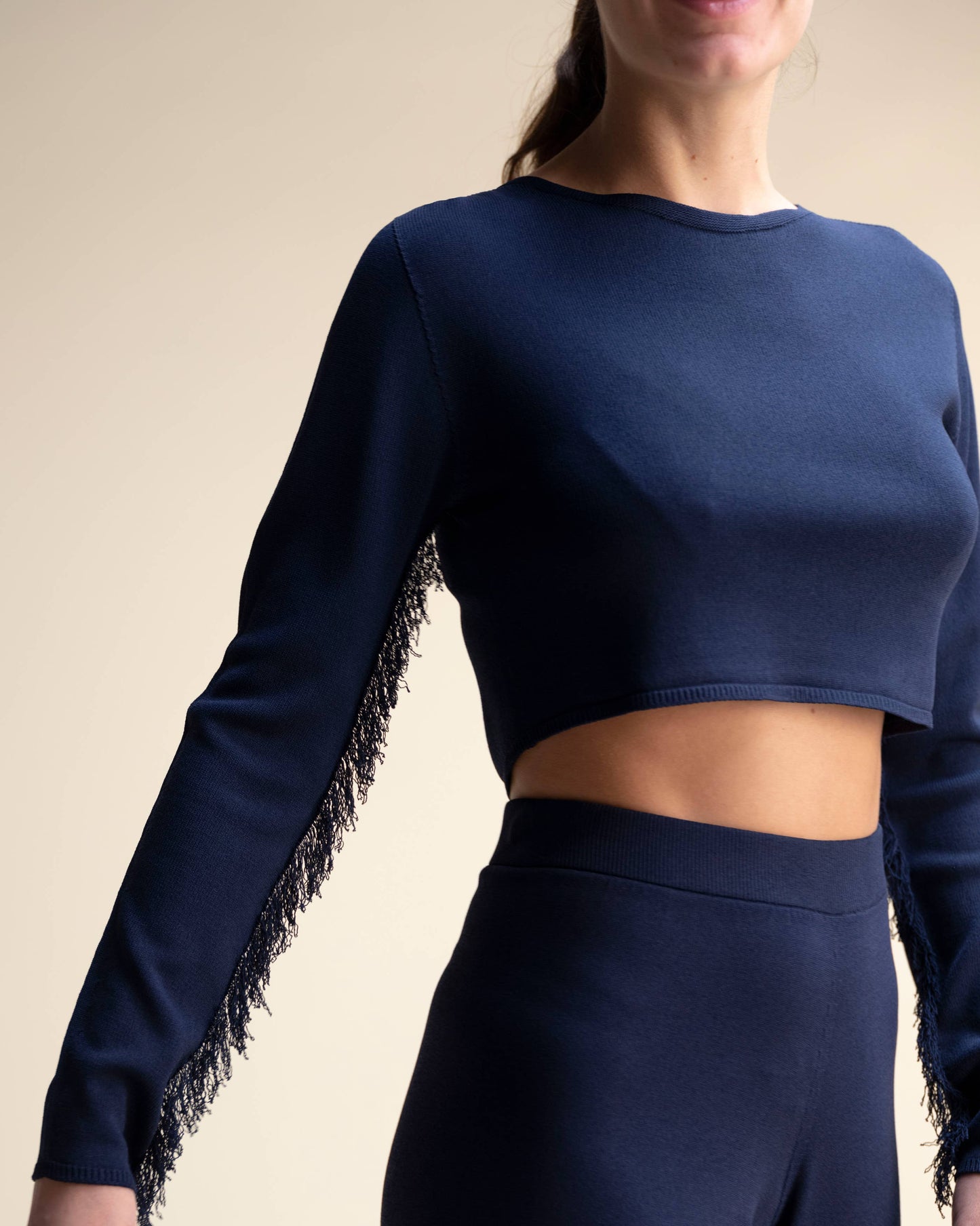Top corto in maglia con frange sulle maniche