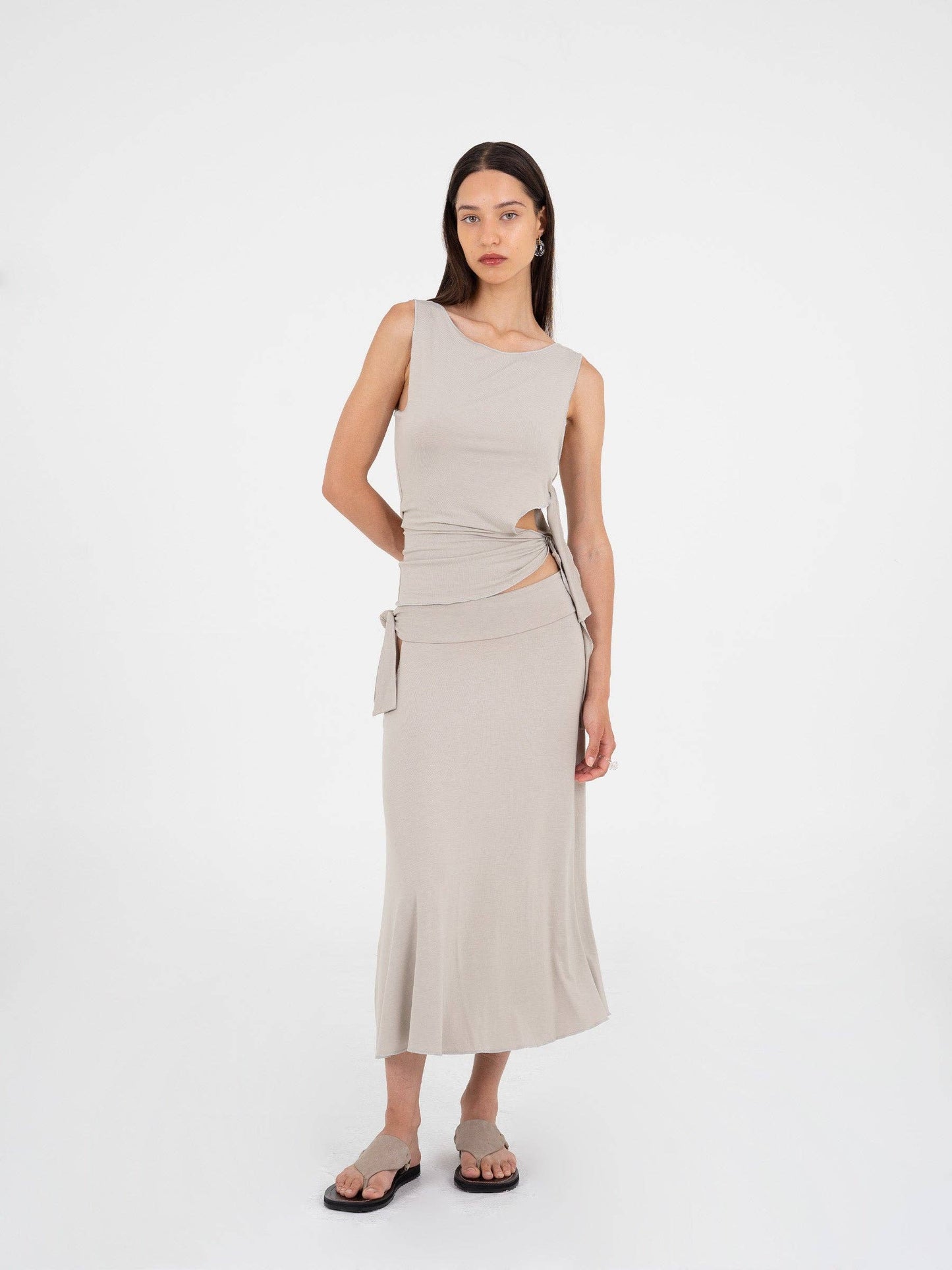 Top asimmetrico luminoso con cut-out e fiocco