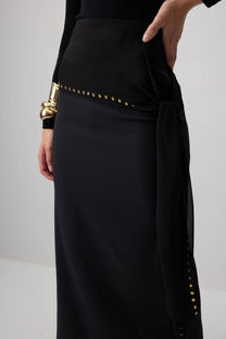 Gonna lunga in crêpe nera con cintura annodata e borchie oro