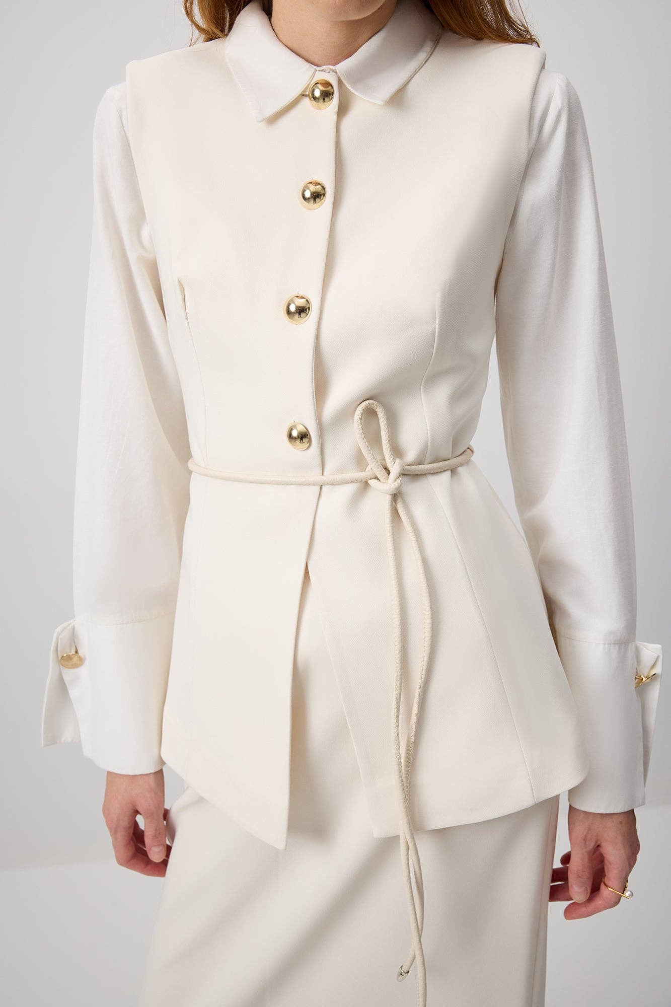Gilet aderente crema con bottoni dorati