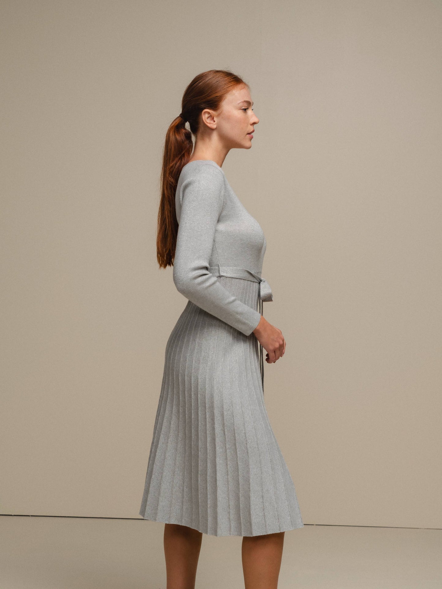 Abito midi in maglia lurex con gonna plissé e cintura