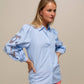 Blusa azzurra con maniche ricamate