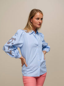 Blusa azzurra con maniche ricamate