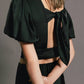 Top crop con maniche a palloncino e fiocco sul retro