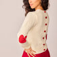 Maglione bianco in maglia con toppe a cuore e bottoni sul retro
