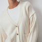 Cardigan in maglia crema con tasche e bottoni