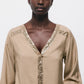 Blusa beige con scollo a V e dettagli di paillettes